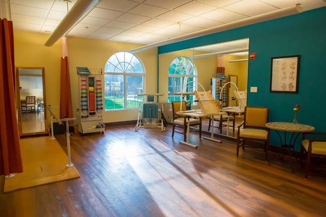 A spacious and well-lit physical therapy room with various exercise equipment.