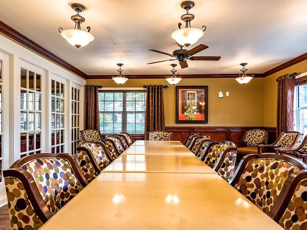 A well-lit meeting room with a long conference table and patterned chairs.