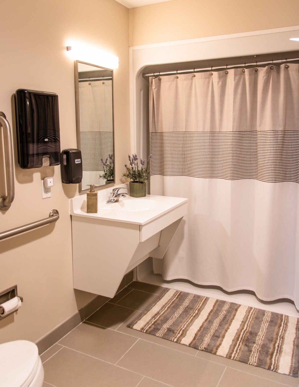 A modern bathroom with a sink, mirror, and shower curtain.