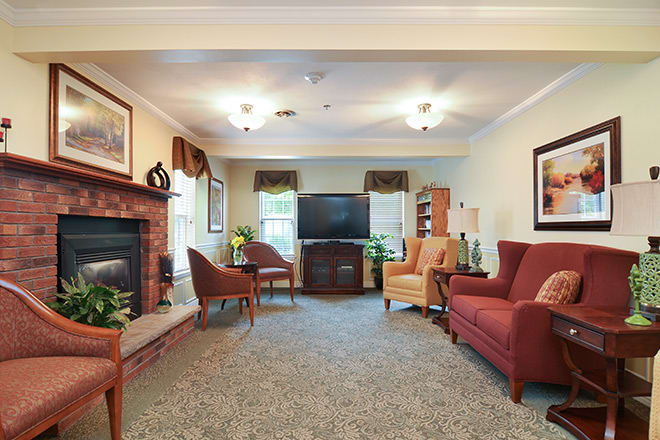 A cozy living room with sofas, a television, and a fireplace.