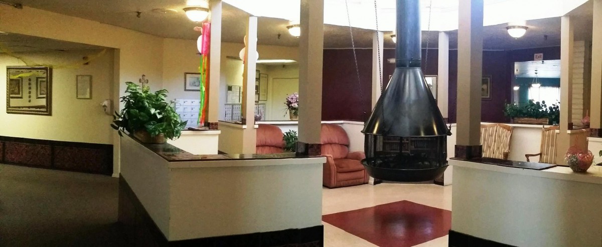 A modern lobby with a central fireplace and comfortable seating.