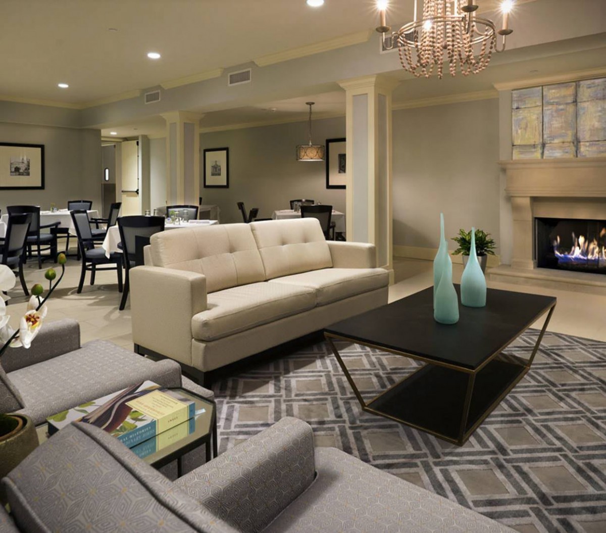 A modern living room featuring a comfortable sofa, elegant chandelier, and stylish coffee table.