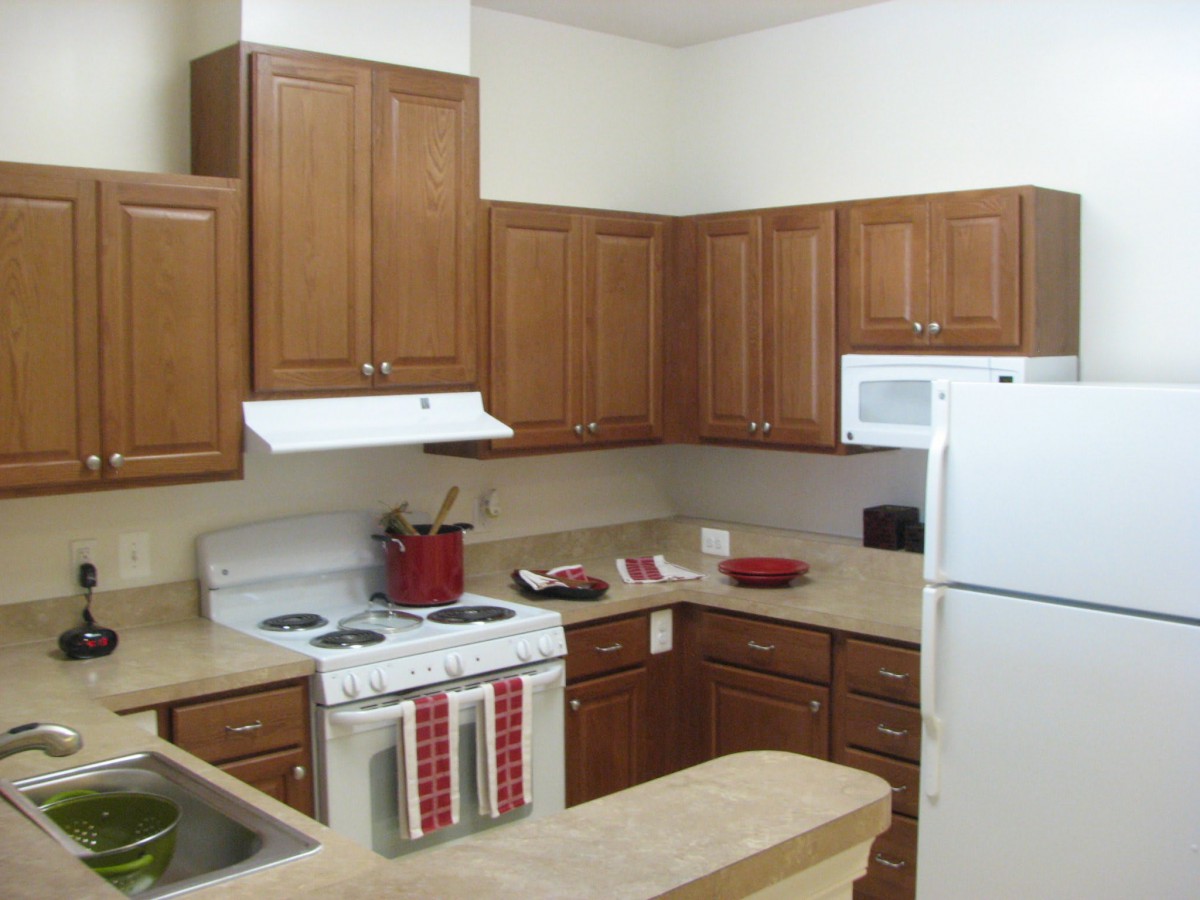 A modern kitchen with wooden cabinets and standard appliances.