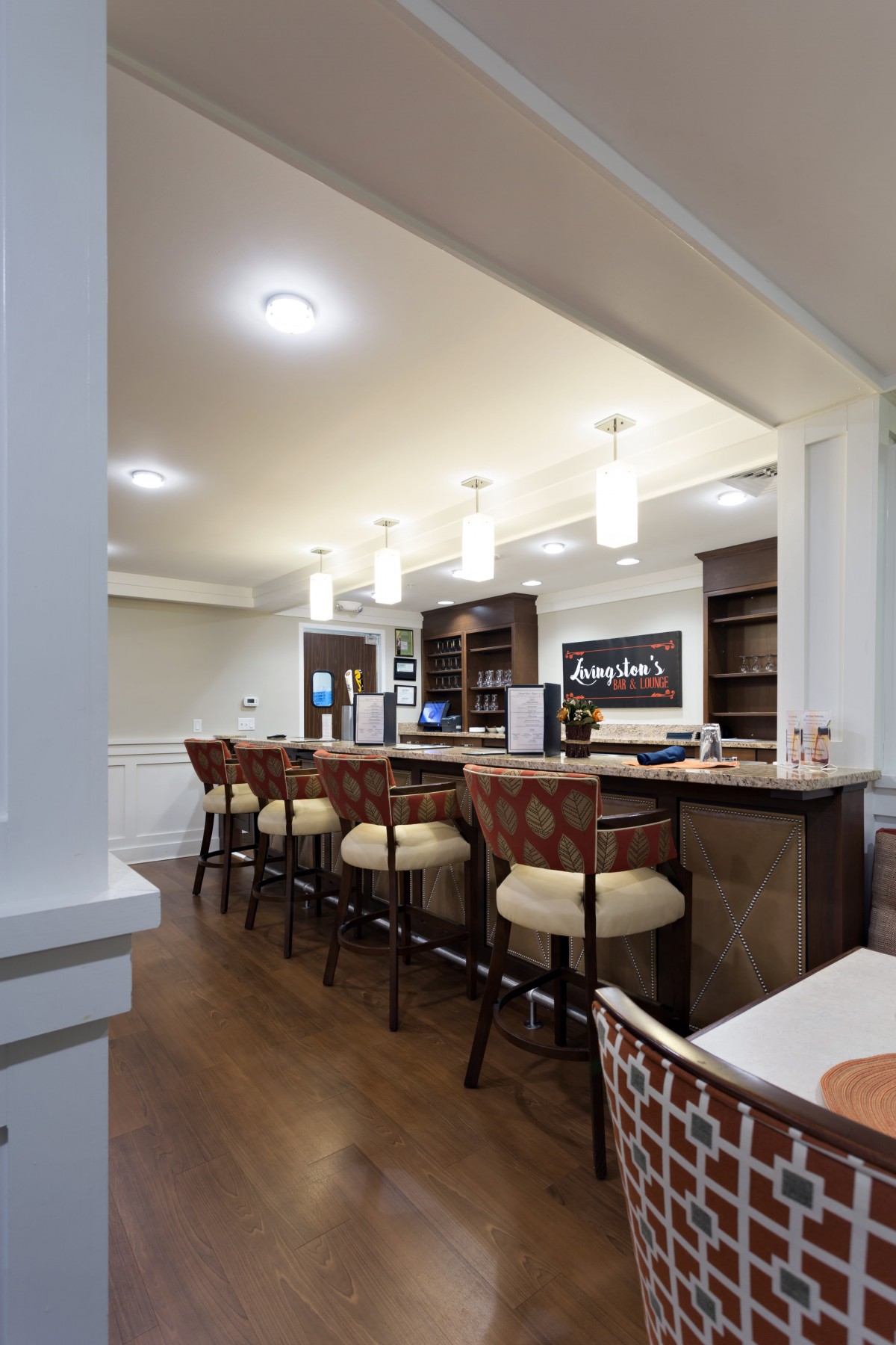 A cozy bar interior with a long counter and comfortable seating.