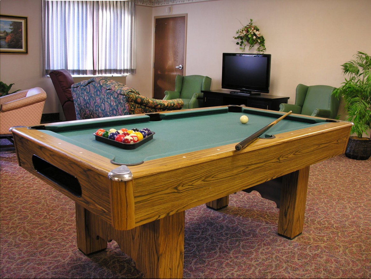 A game room featuring a pool table, television, and comfortable seating.