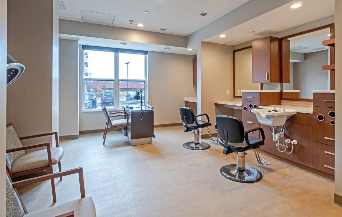 A modern and spacious hair salon with styling chairs and large mirrors.