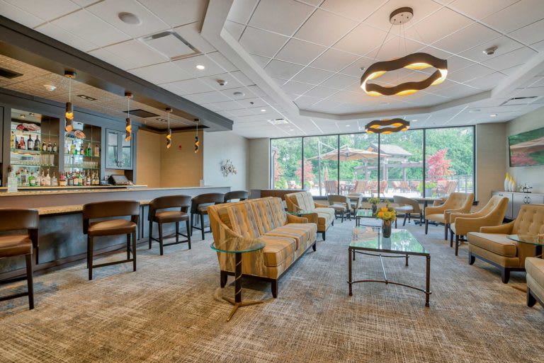 A spacious and modern lobby with comfortable seating, a bar area, and large windows providing natural light.
