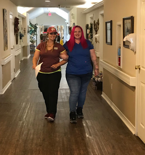 Two friends joyfully walking down a hallway.