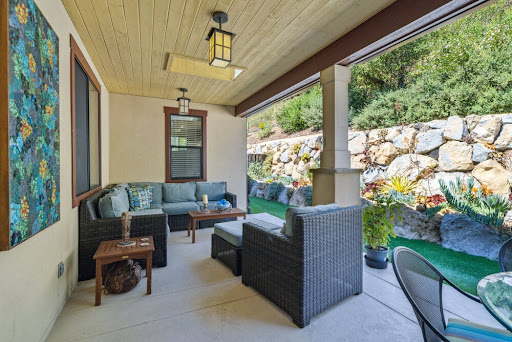 A cozy outdoor porch with comfortable seating and decorative plants, perfect for relaxation.