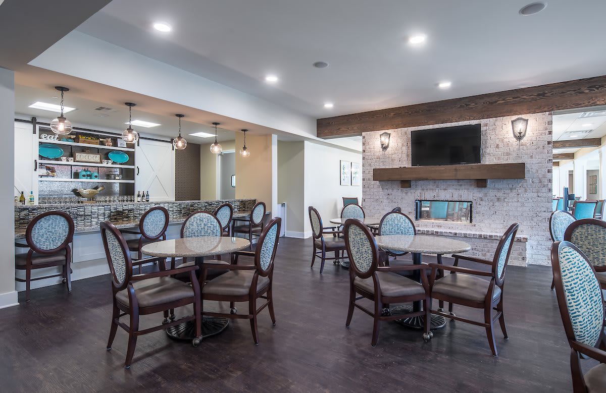 A modern dining room with elegant furniture and a cozy fireplace.