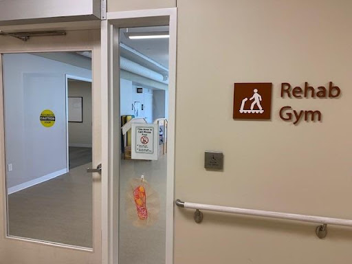 Entrance to a rehabilitation gym, featuring accessibility signage.