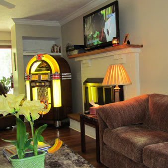 A cozy living room with a vintage jukebox and modern amenities.