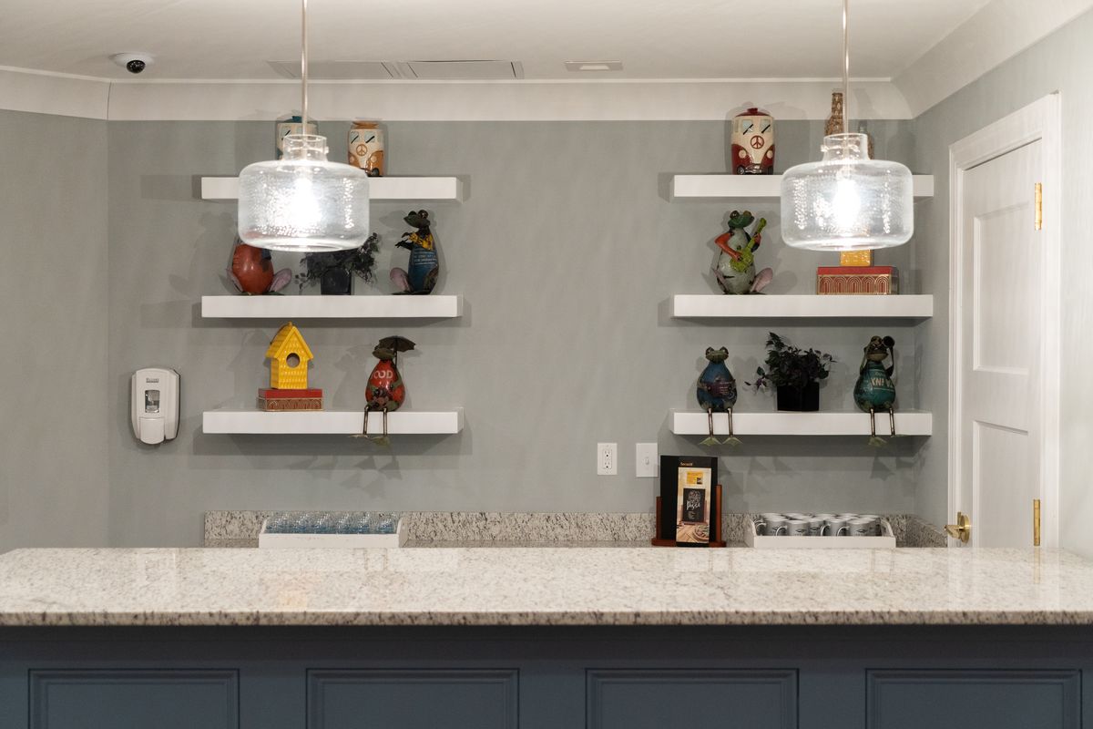 A modern kitchen featuring decorative shelves and stylish pendant lighting above a spacious countertop.