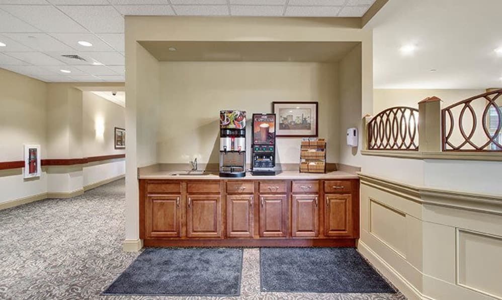 A coffee and snack station with machines and supplies in a commercial interior setting.