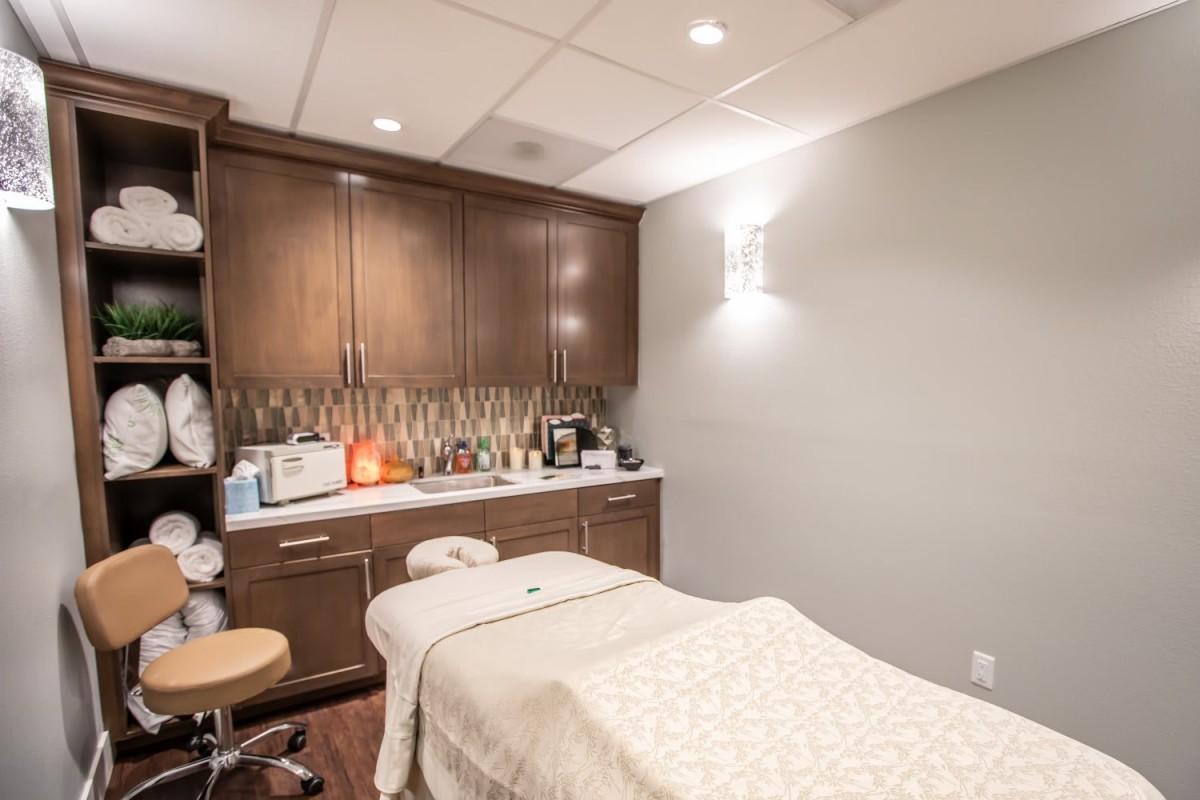 A tranquil massage room with a neatly arranged therapy bed and calming dcor.