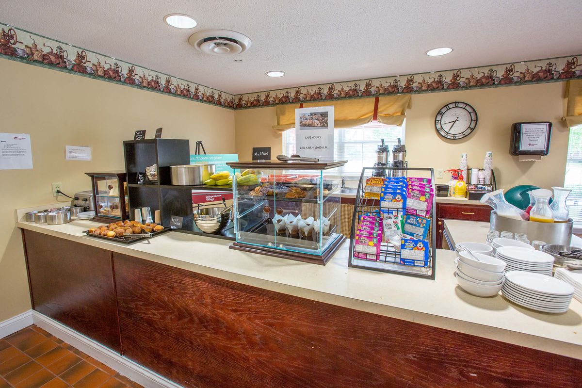 A hotel breakfast area with a variety of self-service food and drinks.