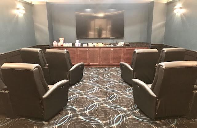 A cozy home theater setup with comfortable seating facing a large screen.