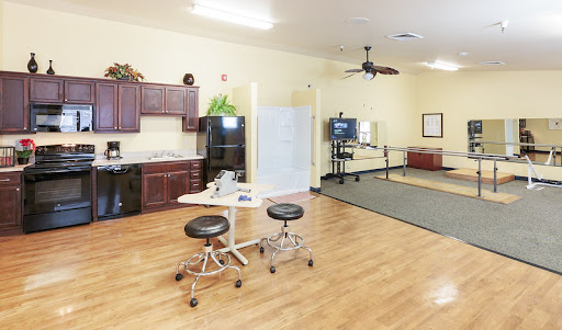 A spacious and well-equipped rehabilitation center featuring a kitchenette and therapy area.