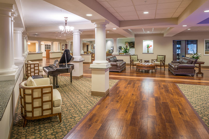Spacious lobby with elegant seating, a piano, and decorative columns.