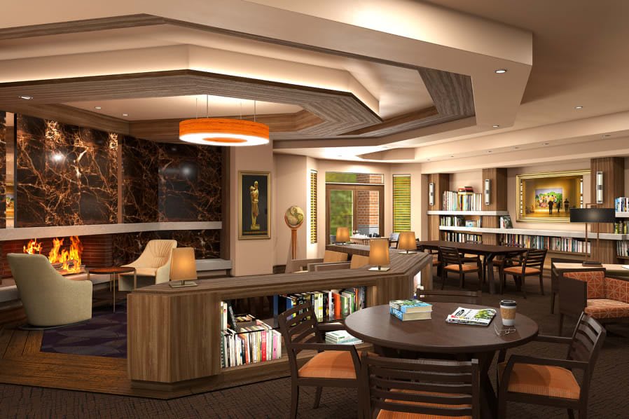 A modern library interior with comfortable seating, contemporary lighting, and shelves filled with books.