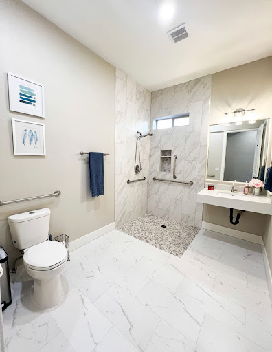A modern bathroom featuring a spacious shower, sleek fixtures, and elegant tile work.