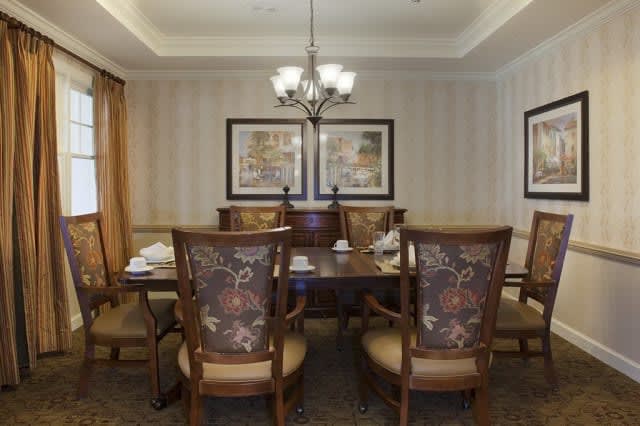 Elegant dining room with a chandelier and classic wooden furniture.