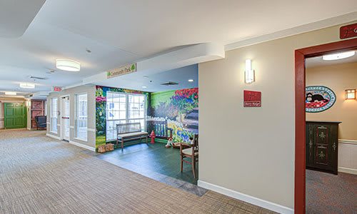 A bright hallway with a colorful children's play area featuring a mural and seating.
