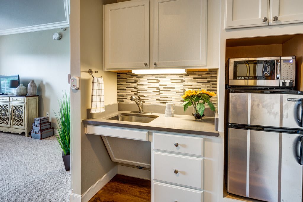 A modern kitchenette with a sleek backsplash and compact design.