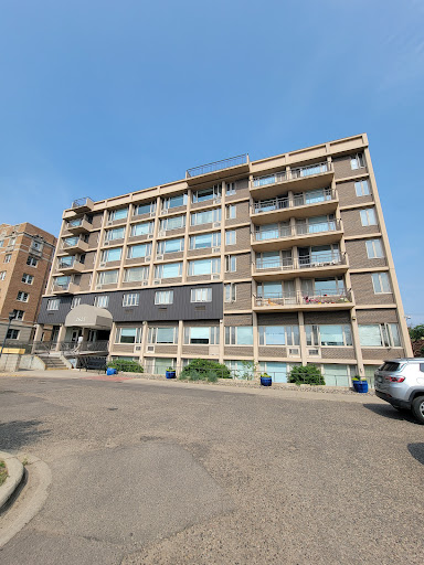 A modern residential building featuring multiple balconies and large windows.