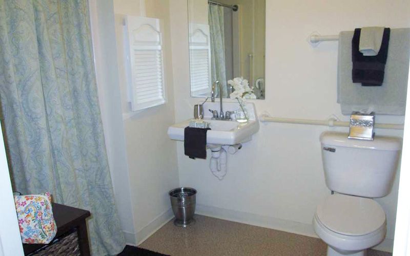 A modern bathroom with a sink, mirror, and towel.