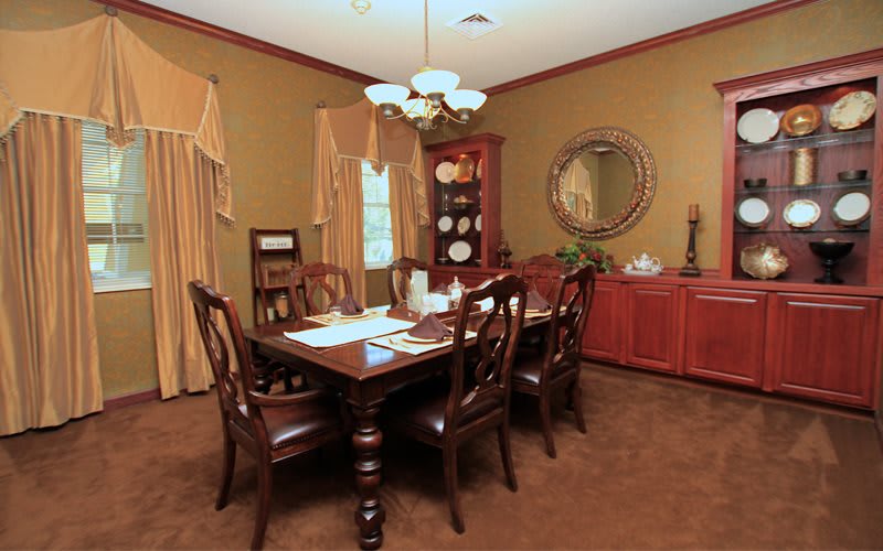 A traditional dining room with a wooden table, chairs, and elegant decor.