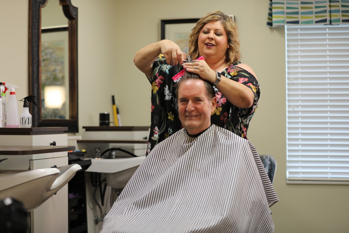 A hair stylist giving a haircut to a customer in a salon.