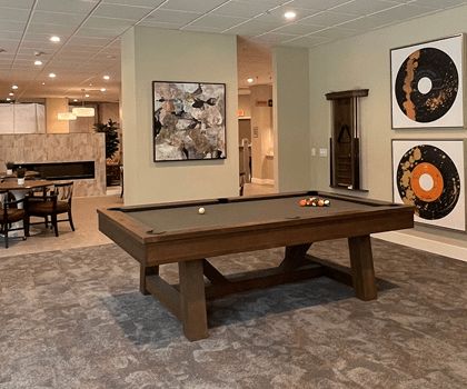 A modern recreation room with a pool table and stylish artwork.