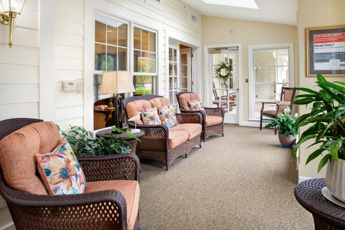 A cozy sunroom with wicker furniture and abundant natural light.