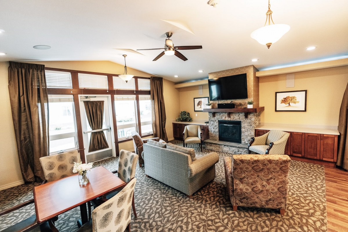 A cozy living room with modern furnishings, featuring a fireplace and flat-screen TV.