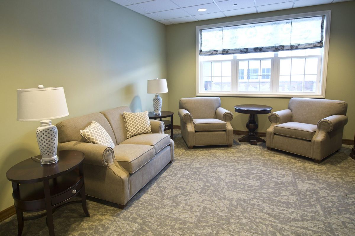 A cozy living room with a sofa, armchairs, and table lamps.