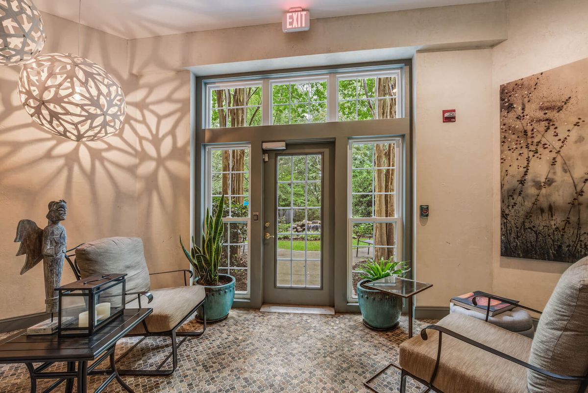 A cozy lobby with modern seating, potted plants, and artistic lighting.