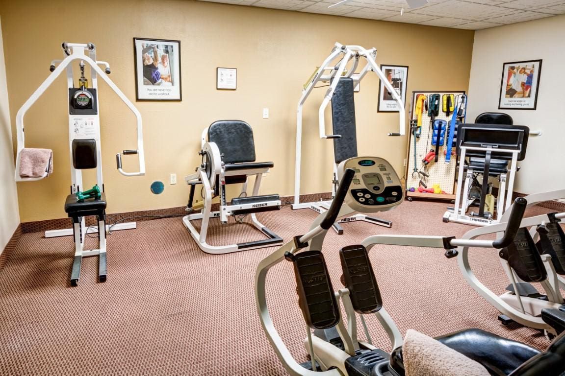 A small gym room with various exercise machines and fitness equipment.