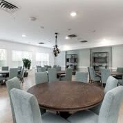 A modern conference room with round tables and cushioned chairs.