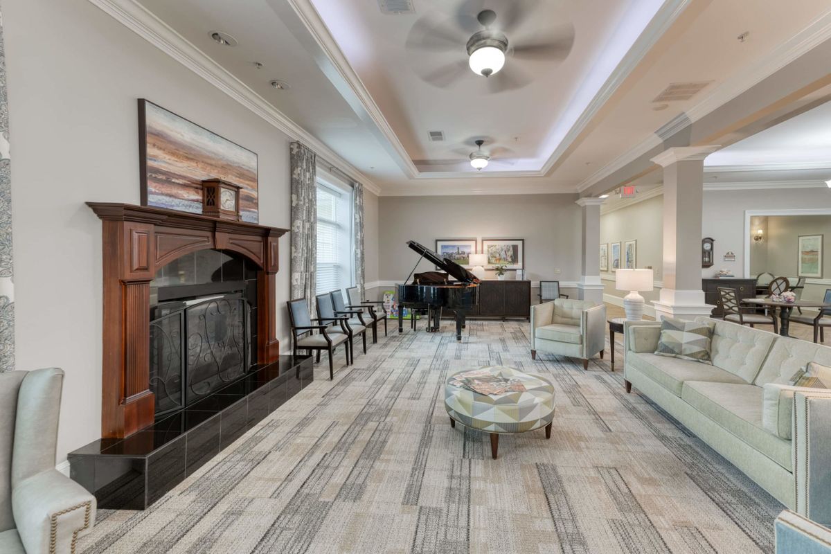 A modern living room featuring a grand piano and a cozy fireplace.
