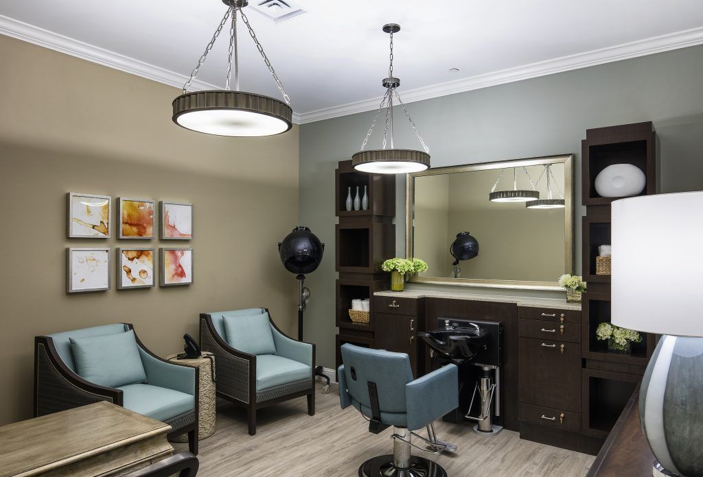 A modern salon interior featuring stylish seating, large mirror, and professional hair styling equipment.