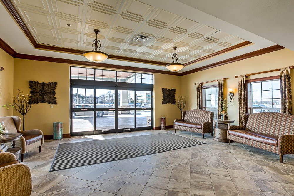 A spacious lobby area with large windows, seating, and elegant lighting.