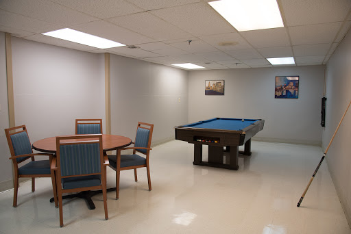 A spacious game room featuring a pool table and a dining area.