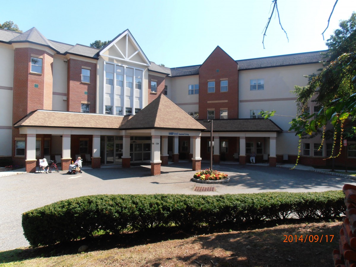 A multi-story building with a main entrance and surrounding landscaping.