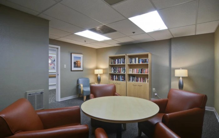 A cozy lounge area with comfortable seating and bookshelves filled with books.
