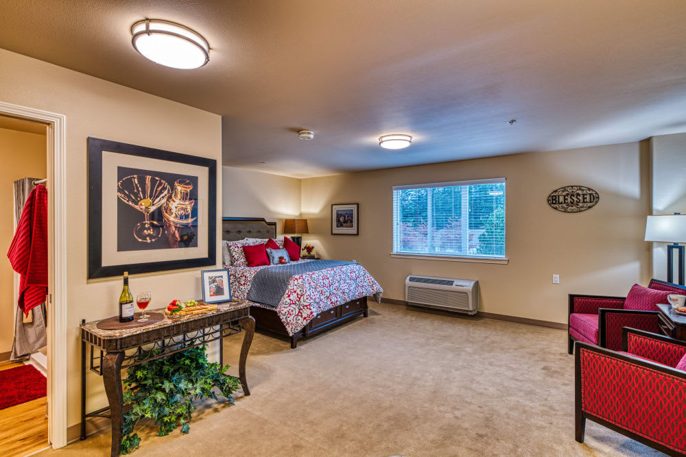 A cozy and well-decorated bedroom with a large window and comfortable furnishings.