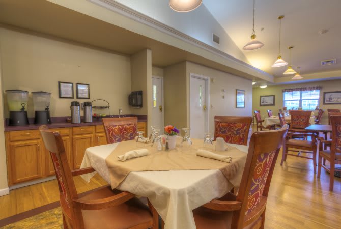 A cozy dining area with elegantly set tables and comfortable chairs.