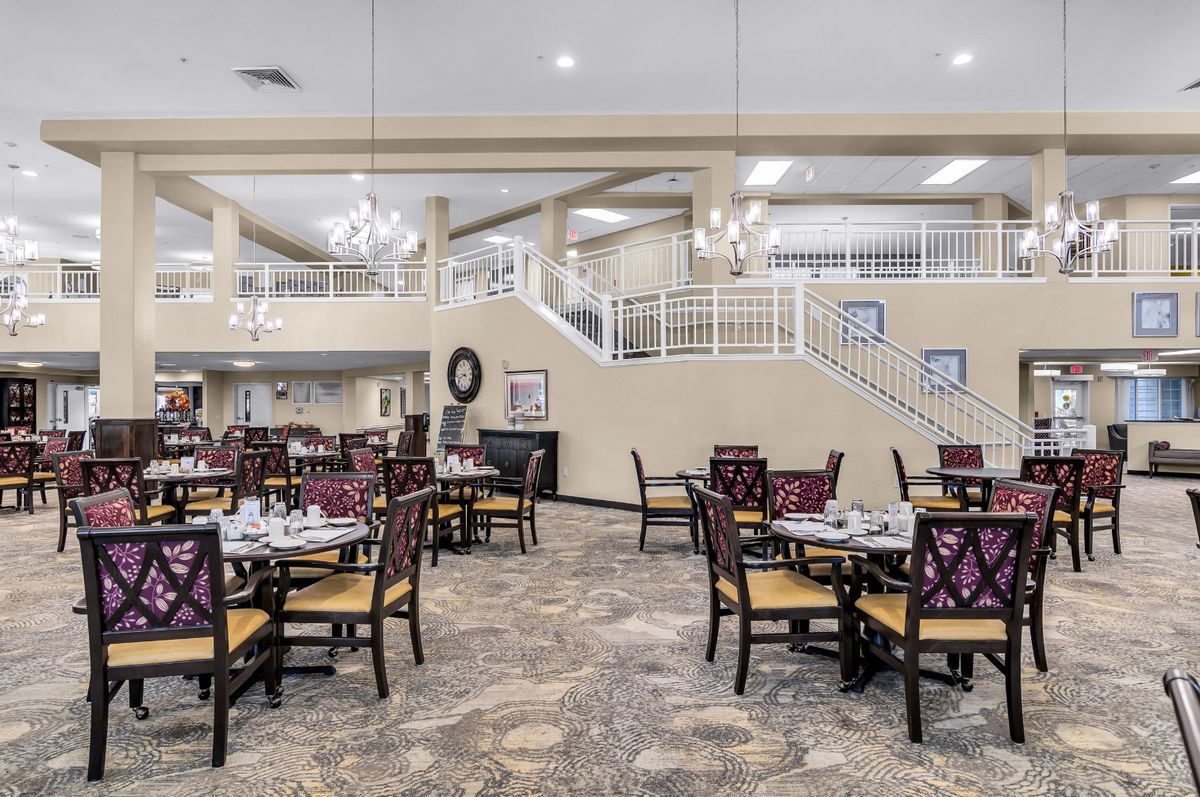 Spacious dining area with elegant chandeliers and neatly arranged tables and chairs.
