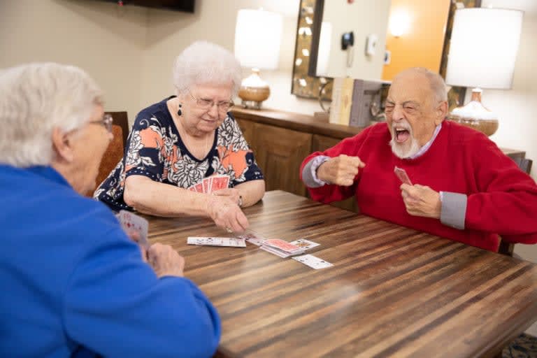 A group of seniors enjoying a card game together indoors.