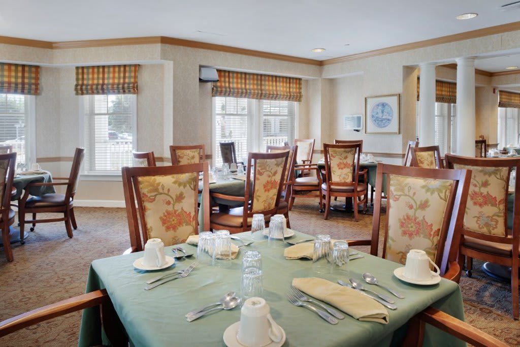 A well-arranged dining room with elegantly set tables and comfortable chairs.